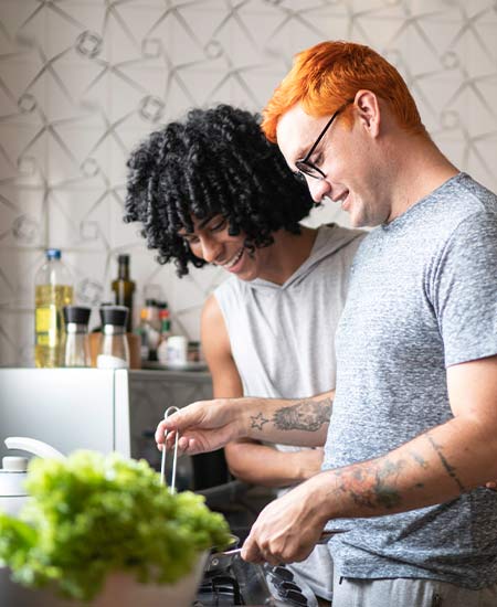 A photo of a couple making dinner in the kitchen.