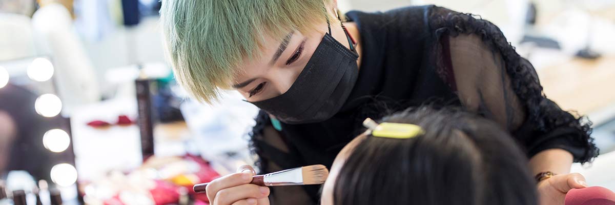 A photo of someone applying a client's makeup.